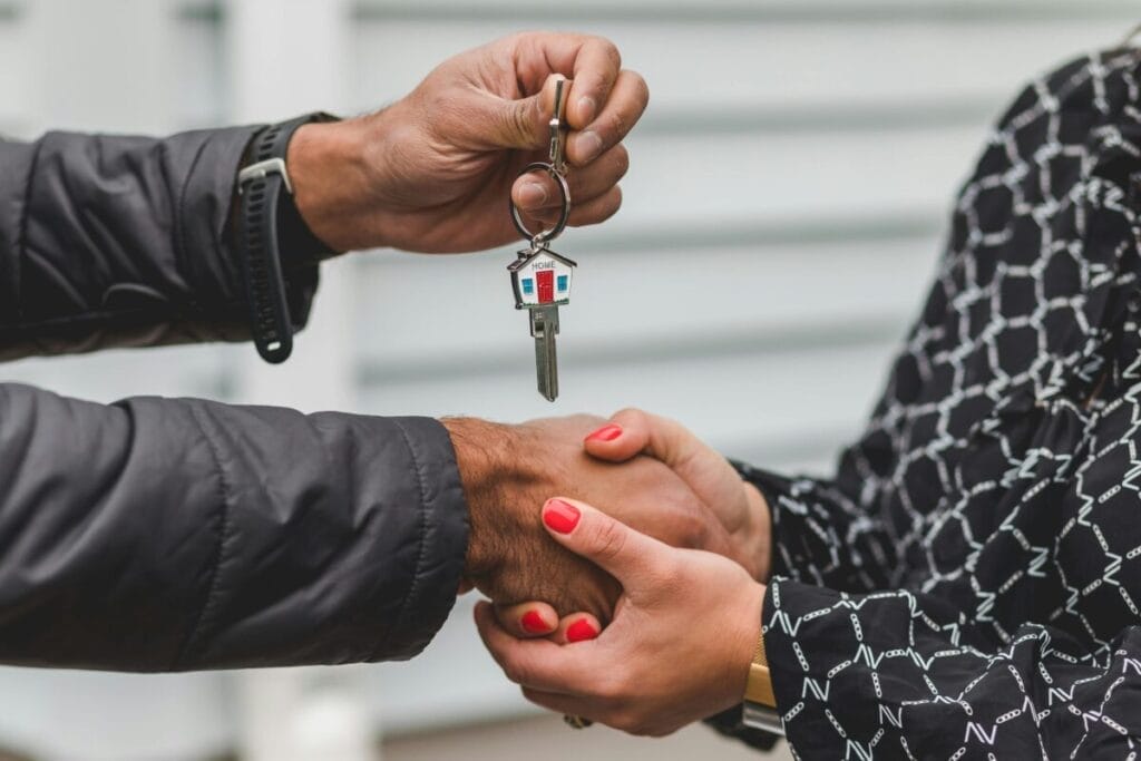 Image: real estate agent handing keys to client